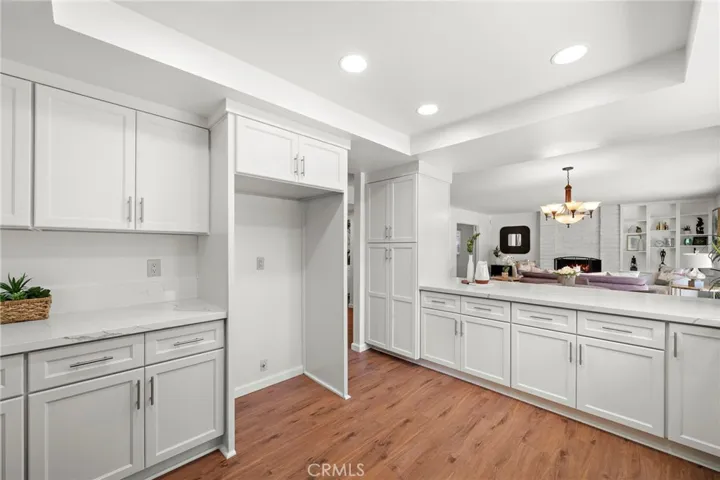 A trey ceiling with recessed lighting and a breakfast bar opens to the inviting family room
