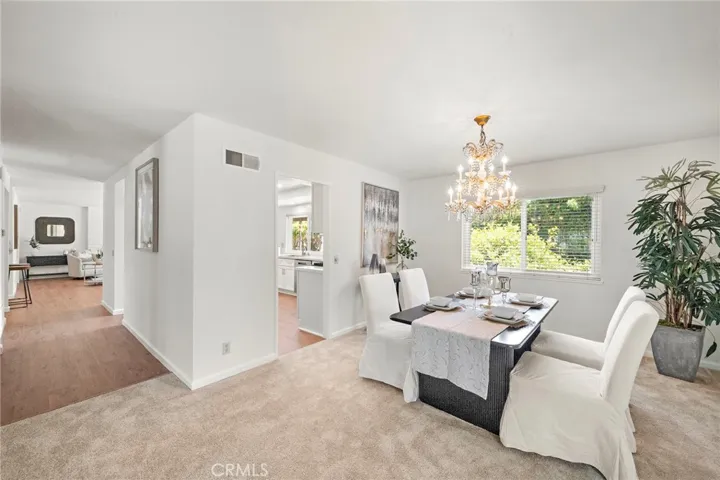 A large adjoining dining room, complete with a beautiful chandelier, provides easy access to the kitchen for seamless entertaining