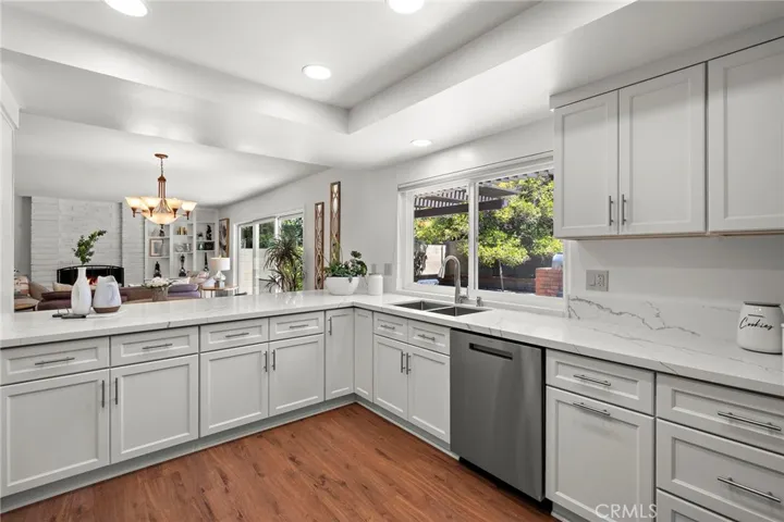 The kitchen is a chef’s dream, featuring gorgeous quartz countertops, custom cabinetry including a spacious pantry and cabinets with soft-close pull-out drawers, and two lazy Susan corners.