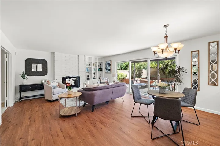 An inviting family room which includes a custom brick fireplace, built-in bookshelves, wet bar with cabinets and display shelves—perfect for gatherings.