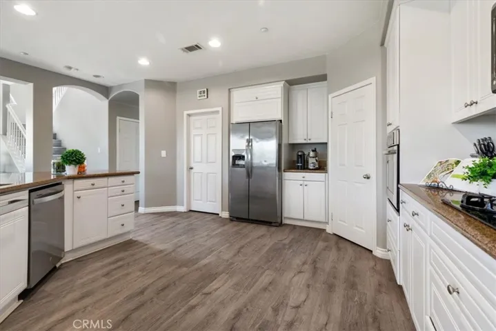 The expansive center island offers additional prep space and seating, while the open-concept layout flows effortlessly into the living and dining areas.