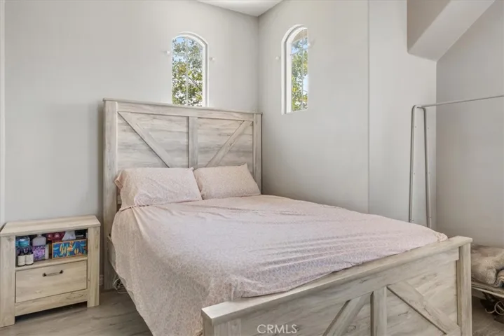 Tucked away on the second floor, this charming bedroom boasts beautiful architectural detail with twin arched windows and high ceilings. It’s the perfect setup for multigenerational living, guests, or a home office.