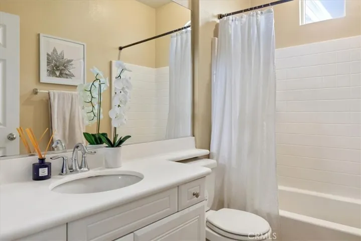 This spacious shared bathroom is thoughtfully designed with functionality in mind, featuring dual sinks set into a long vanity—perfect for busy mornings or shared use.