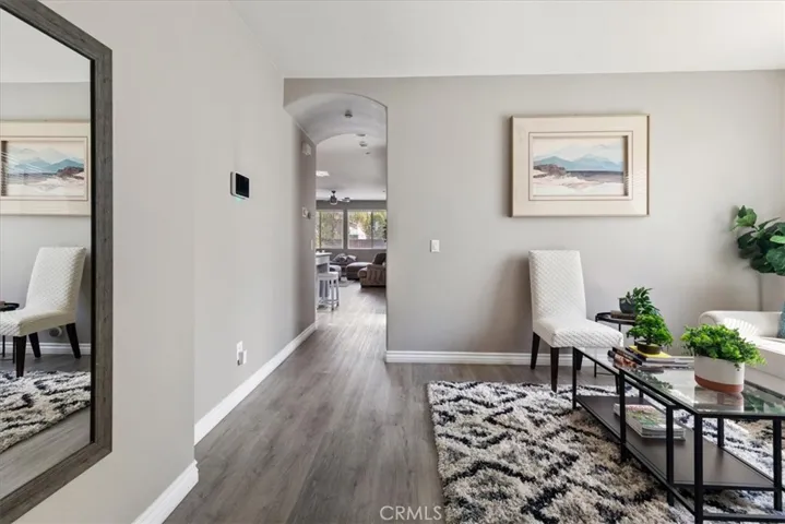 The wide hallway features sleek wood-look flooring, recessed lighting, and a modern console table perfect for styling or added functionality.