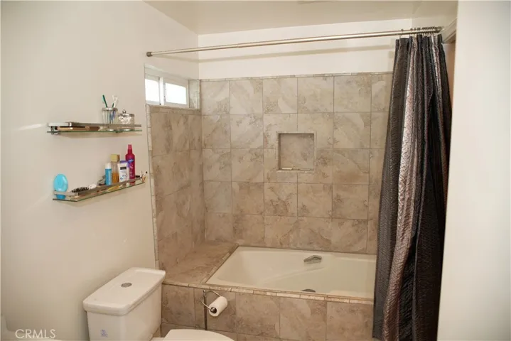 Large tub with shower and new toilet. Closet to the right.
