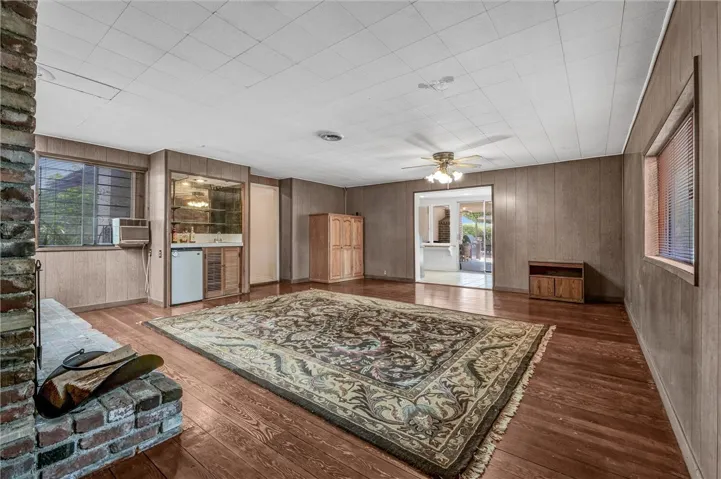 Spacious family room with wood flooring, fireplace, ceiling fan & skylight.