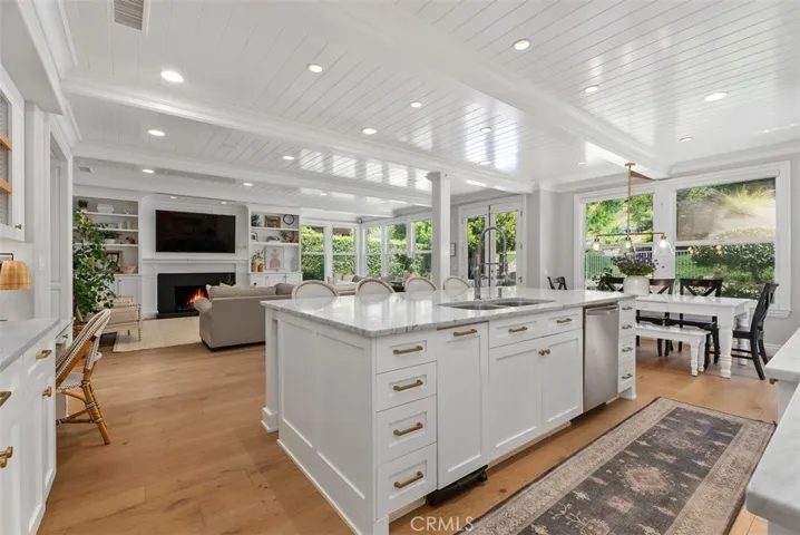 At the heart of the home,a stunning and oversized center island crafted from solid marble makes a bold statement.Love this kitchen with the custom wood-planked ceilings. BREATHTAKING!