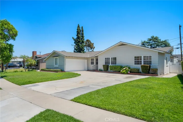 Charming Single-Level Home in a Tranquil Quiet Anaheim Neighborhood. The front of the home offers fantastic curb appeal, enhanced by a long, curved driveway leading to a direct-access two-car garage—perfect for multiple vehicles or guests.