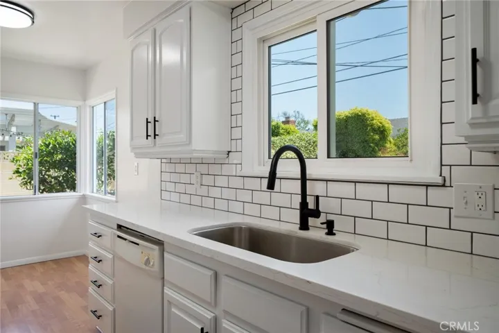 The kitchen has been tastefully upgraded with freshly painted cabinets, sleek quartz countertops, and a custom tile backsplash, giving it a clean, contemporary look.