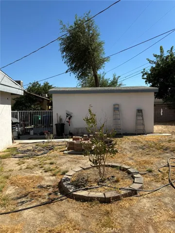 Side view of detached garage and partially landscaped backyard area. Photo shows potential for outdoor customization.