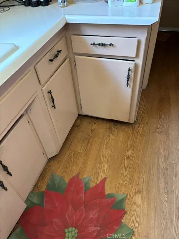 View of lower kitchen cabinetry and laminate flooring.