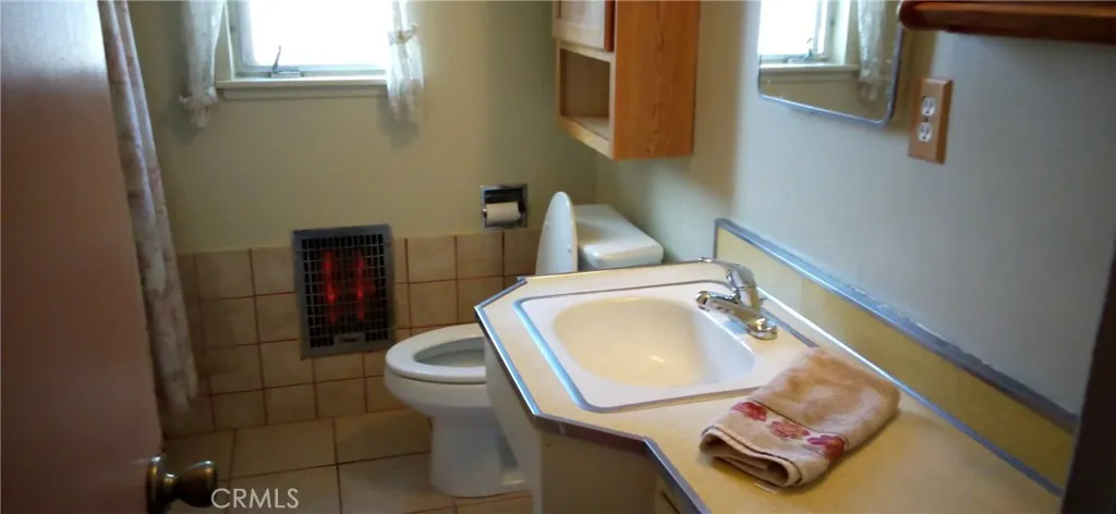 Bathroom sink view and operational electric heater.