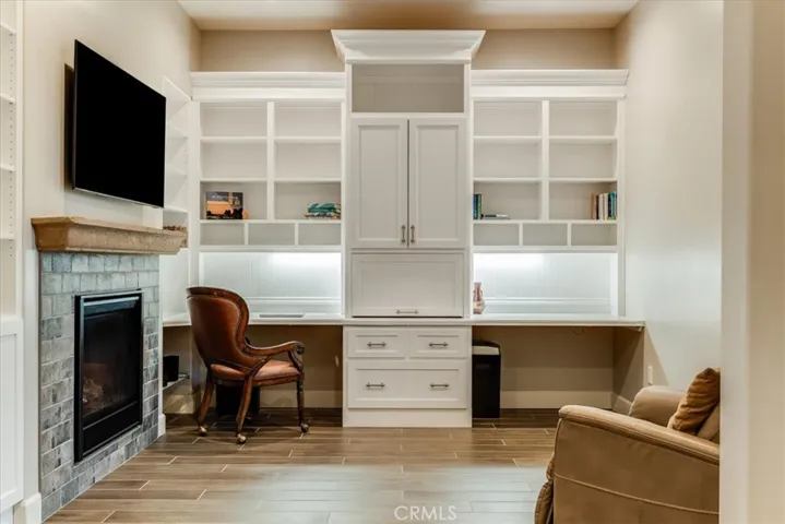 Office with custom built-in cabinetry and dual-sided fireplace.
