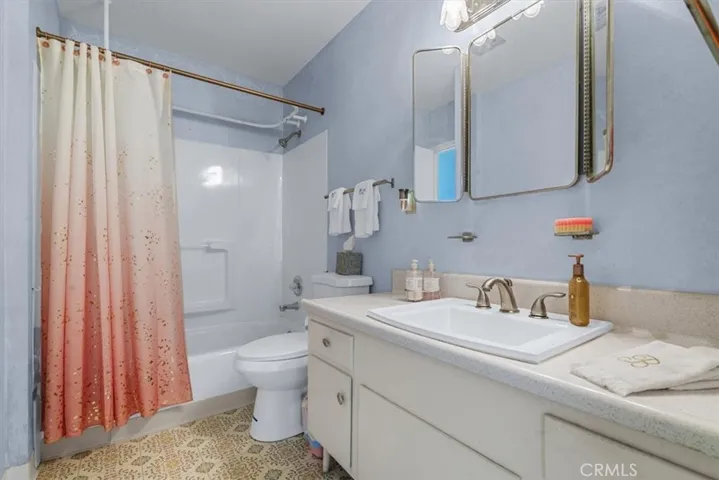 The full bathroom in hallway with an updated sink and shower over tub, serves guests and Bedrooms 2 and 3.