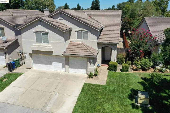 View of front of home featuring a tile roof, an attached garage, stucco siding, and concrete driveway
