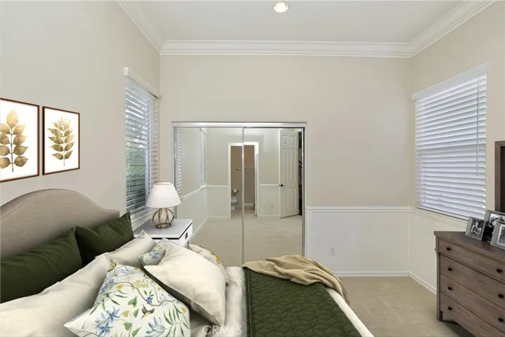 Main floor bedroom with mirrored wardrobe doors and adjoining private full bath