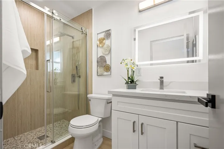Primary bath, beautifully tile with barn door shower doors, LED mirrors