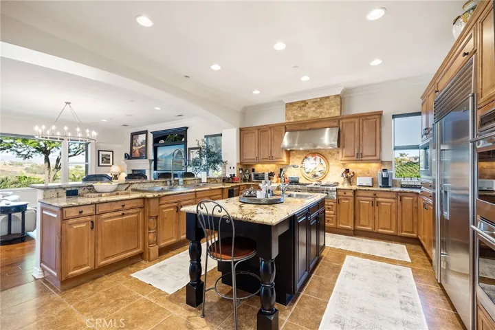 Large Gourmet kitchen with gorgeous granite, light cabinets, Wolf Stove and Refrigerator, Center Island with vegetable sink.