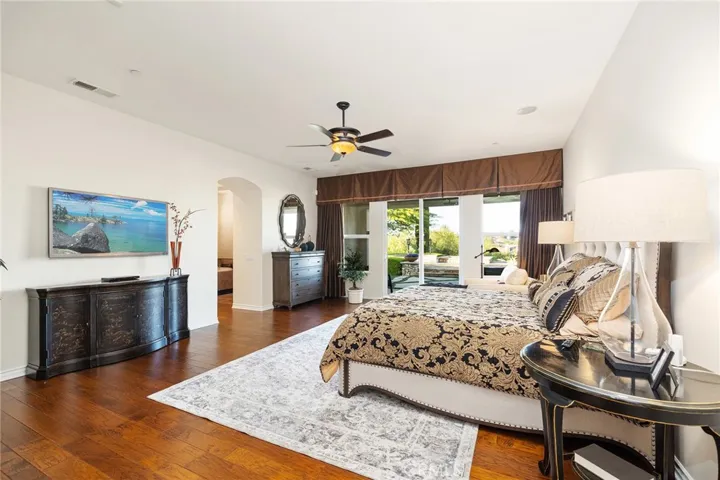 Spacious Primary Bedroom with Wood flooring, ceiling fans, sliding doors to Private back yard patio