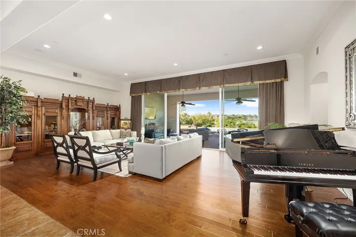 Spacious Formal Living Room with doors opening to covered patio.  There is room for a large dining room table where the piano currently sits.