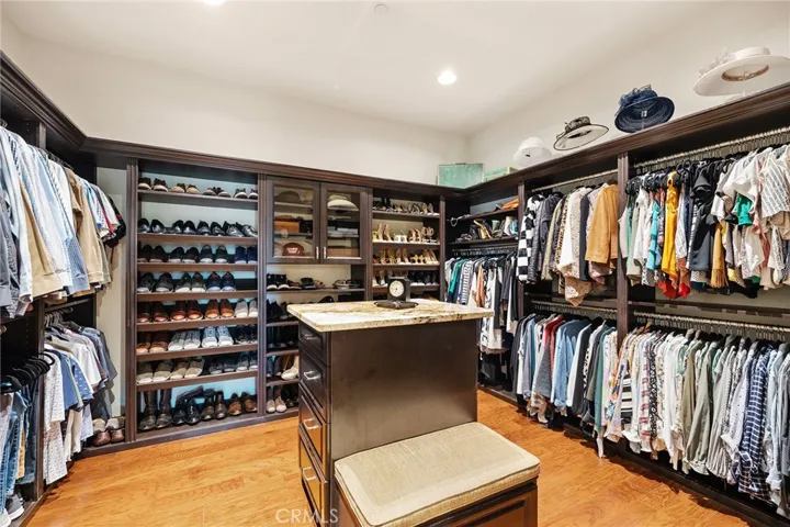 Spectacular closet with Custom Organizers, wood flooring