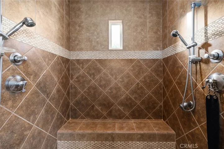 Shower in Primary Bath with double shower heads and bench