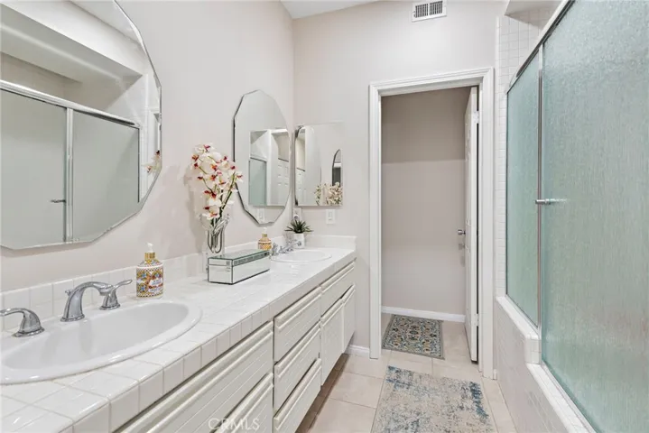 Spacious primary bathroom featuring dual sinks, and a separate toilet room for added privacy.