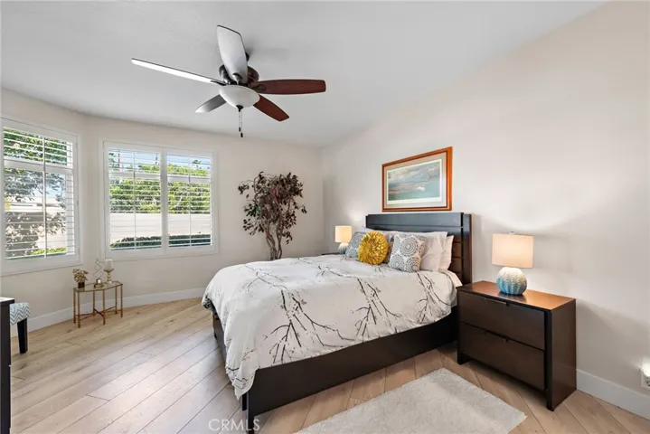 The spacious primary bedroom is filled with natural light, featuring oversized windows, soft tones, and a serene ambiance.