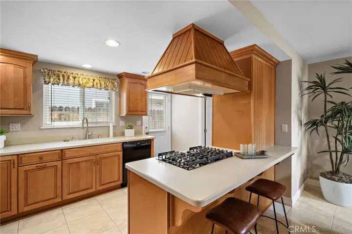 kitchen showcasing Corian countertops, gas cooktop with vent hood