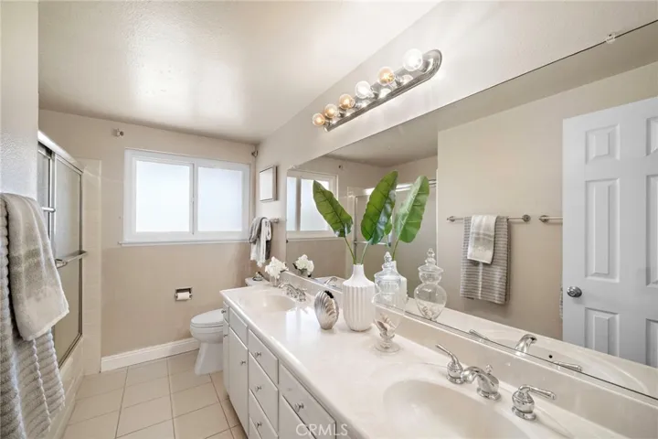 Dual Sinks In Guest Hall Bathroom and Tub Shower Combination