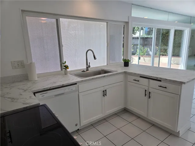 Upgraded kitchen features dishwasher, new electric stove new stylish formica counter top and stainless steel barn sink
