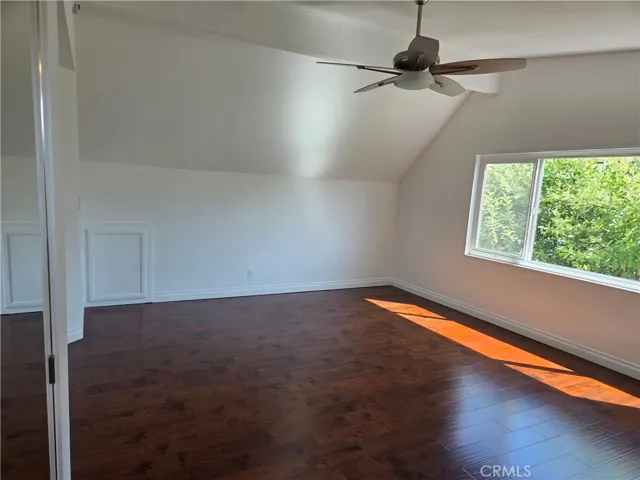 Large primary bedroom features ceiling fan and cherry laminate flooring, double pane windows