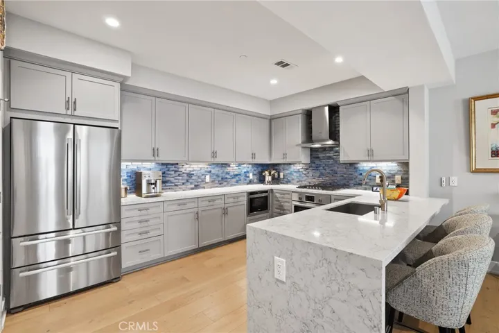 Stainless appliances and waterfall counter to floor