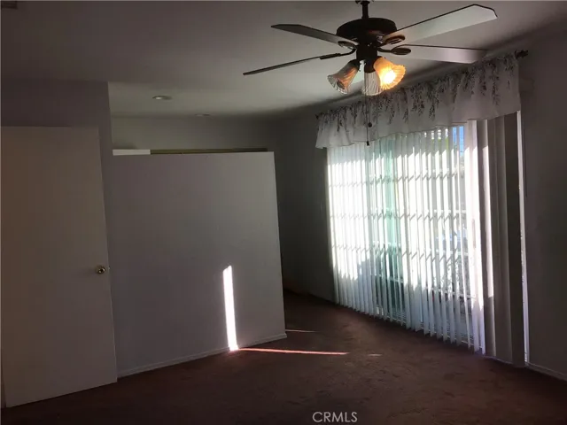 Primary bedroom view of updated slider door and access to closet and bathroom second sink and entry to updated bathroom