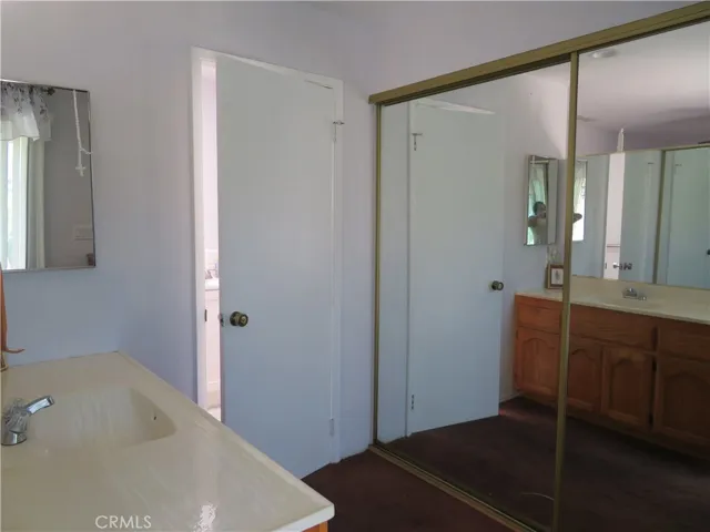 Primary bathroom second sink and entry to bathroom primary w/mirror closet doors