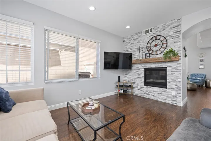 The spacious family room invites you to unwind in comfort with its elegant quartz stacked-stone fireplace.