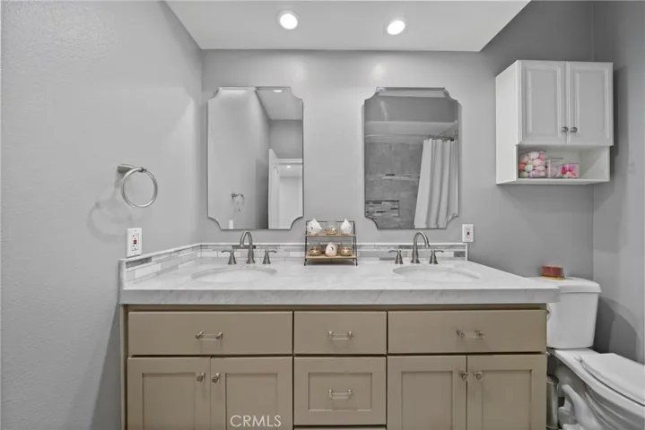 The hallway bath offers dual sinks provide plenty of space for busy mornings or shared use.