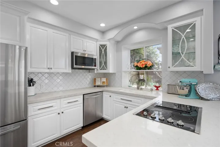 The fully remodeled kitchen features white shaker cabinetry and stunning quartz countertops.