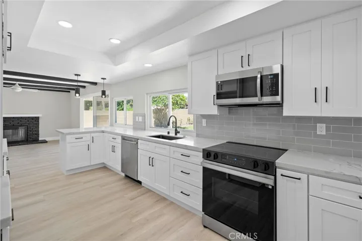Stylish open shelves, recessed lighting, and modern finishes elevate this kitchen’s design.