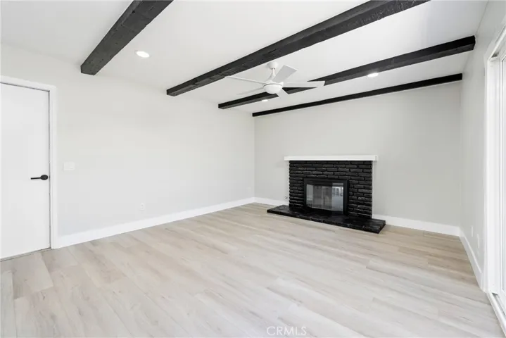 Black ceiling beams add a bold touch to this warm and inviting living room.