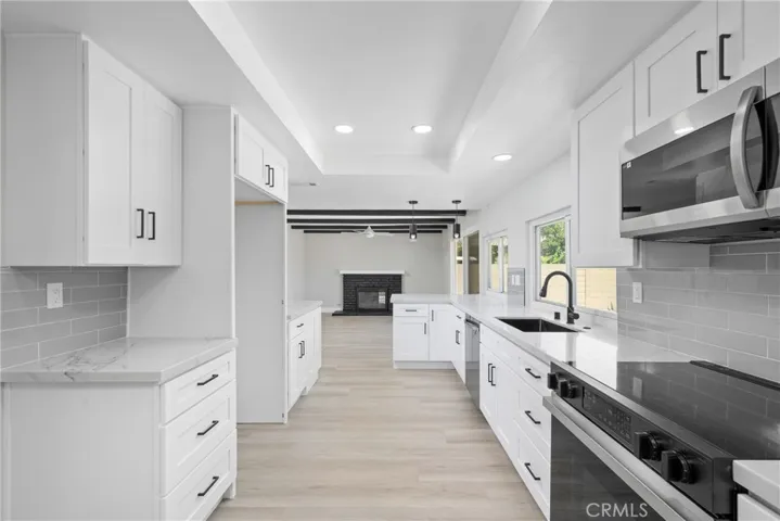 Fully remodeled kitchen with white shaker cabinets, quartz countertops, and stainless steel appliances.