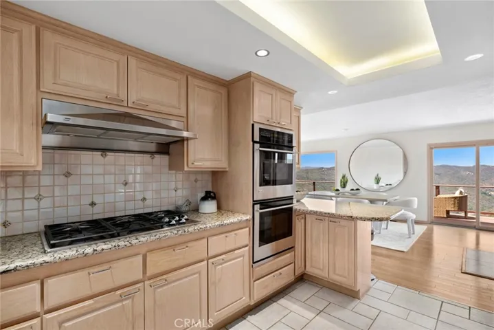  The chef’s kitchen is appointed with granite countertops, premium stainless steel appliances, and bar seating, effortlessly blending into the adjacent dining space.