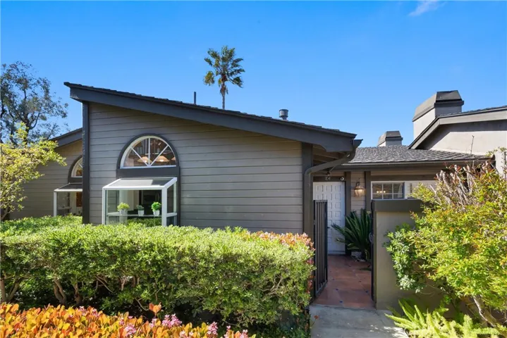 The Front of the Home with a Gate and Spacious Front Patio