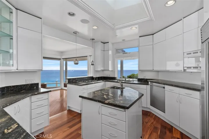 An abundance of cabinets, drawers, display glass front cabinet, a desk area and pull outs under the cabinets at the kick place for additional storage great for serving platters, cutting boards and those oversized cookie sheets.  There's even a pull out with a stand for your mixer on hinges that lock in place so you never have to lift or store the big mixer on the counter.
