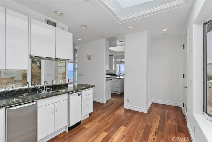 Wet bar with mirrored backsplace reflects the poolside.  Easy access from the poolside to the dinette area, to the kitchen or the back patio area of the house.  All ideal for entertaining or privacy, which ever works best.