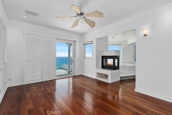 On the other side of the fireplace is an underglass block lite step-in surrounded in marble, jetted tub with incredible views of the ocean.