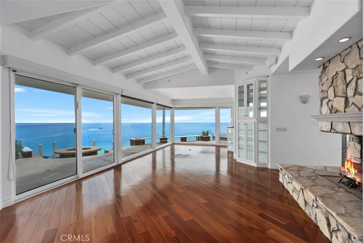 Around the corner from one living room with fireplace is a second living room with spectacular views, opening to the dining area with custom windowed shelves and lights to accent anything displayed.