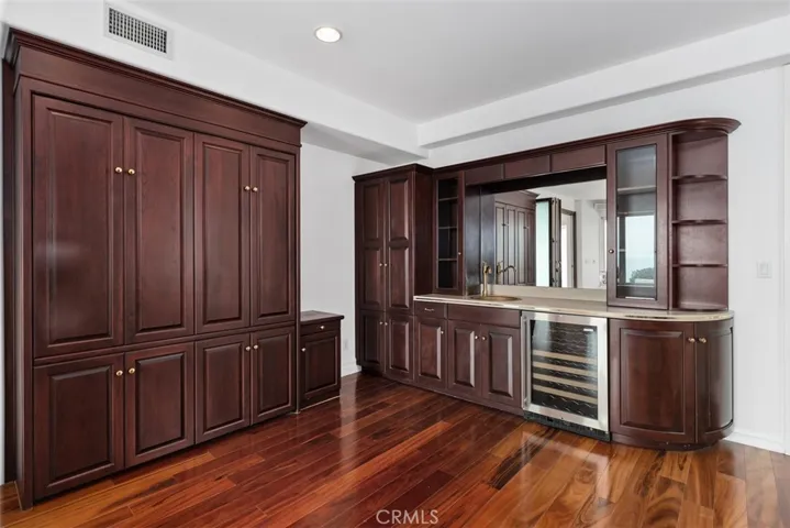this wet bar contains a safe and the left side opens and both doors have extending, swing out shelves.  The bar above the mirror contains downlights, while the mirror reflects the ocean views.