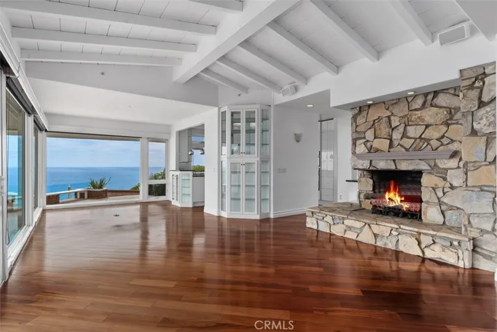 A closer look at the custom build-in full floor to ceiling glass faced cabinet with lights and a second one just below the counter of the kitchen, both wonderful display cabinets with lights. Look at the beautiful custom rock fireplace.  Floors from the rain forest. Beautifully designed ceiling in the ocean front living room. 
