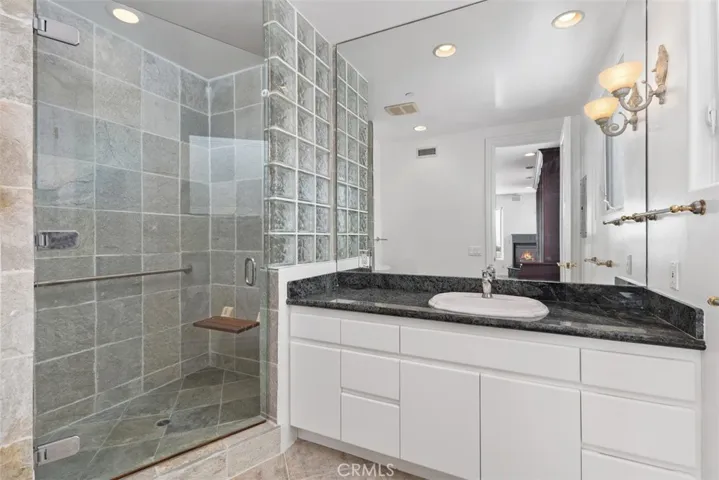 The bedroom/office/library had a walk-in glass faced and blocked wall, ceiling to backsplash mirrors, granite counters and ample cabinets and drawers for storage.  Beautiful stone walls and an abundance of natural light.